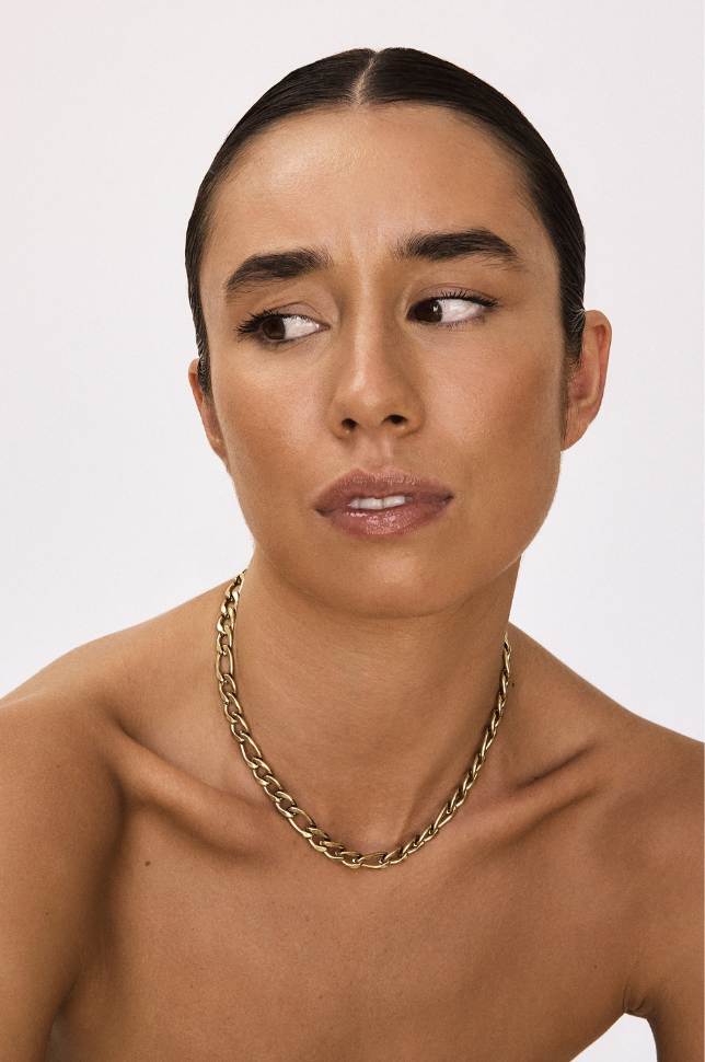 Model pulling face and wearing a gold chunky bold chain statement necklace from australian online store Martini Street which sells waterproof, high quality jewellery.