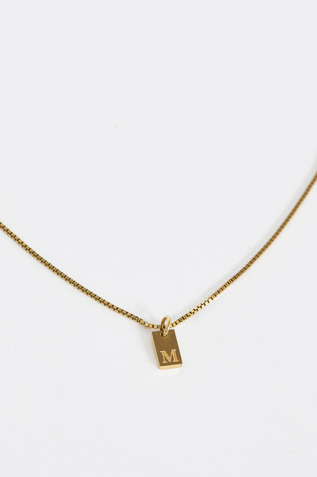 Close up of gold initial letter pendant necklace from australian online store Martini Street which sells waterproof, high quality jewellery.